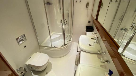 Bathroom with shower, toilet, and double sinks